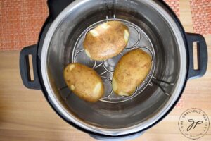 Step three is to place the potatoes on the trivet.