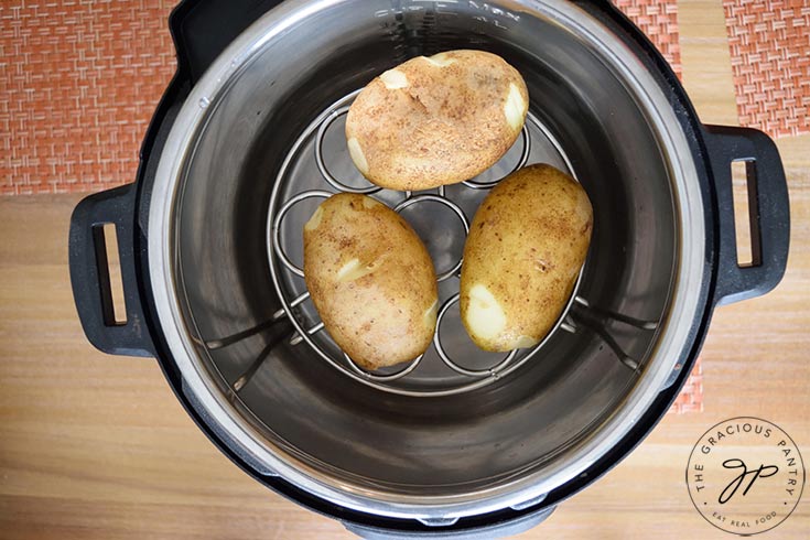 Step four for making these Instant Pot Baked Potatoes is to add water to the IP insert.