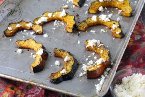 Step nine of this Roasted Acorn Squash recipe is to sprinkle the squash with feta cheese crumbles.
