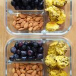 Two containers filled with mini egg muffins, blueberries and raw almonds sit next to each other, ready to go into the fridge for busy mornings. This is part of the Eggs and Oats Meal prep Plan