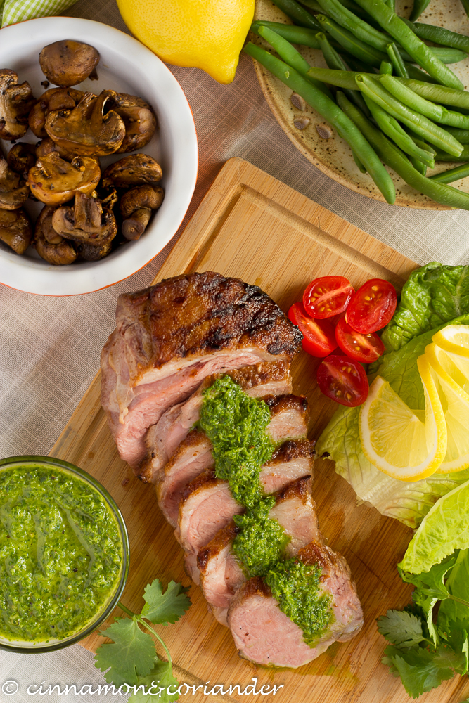 Lamb Sirloin with Chimichurry Sauce sitting on a cutting board, sliced, in this guide to 15 Clean Eating Easter Recipes