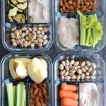 Four meal prep containers all filled with different snack combinations.