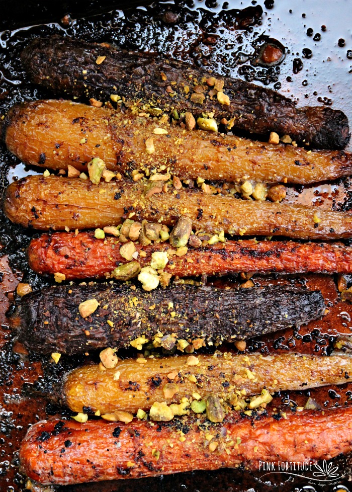 A close up of roasted carrots on a baking pan.