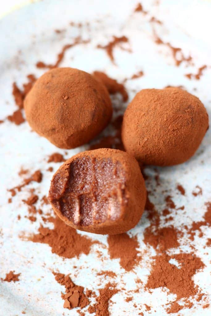 Three easter truffles on a white background. One has a bit taken out of it.