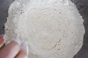 The first step in this guide to making homemade pasta is to put the flour into a large mixing bowl and make a well in the center of it for the water.