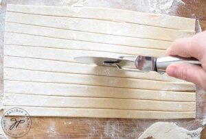 Cut the pasta dough into noodle-size strips.