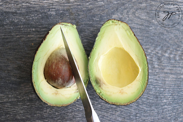 Showing the knife pressed into the seed for removal.