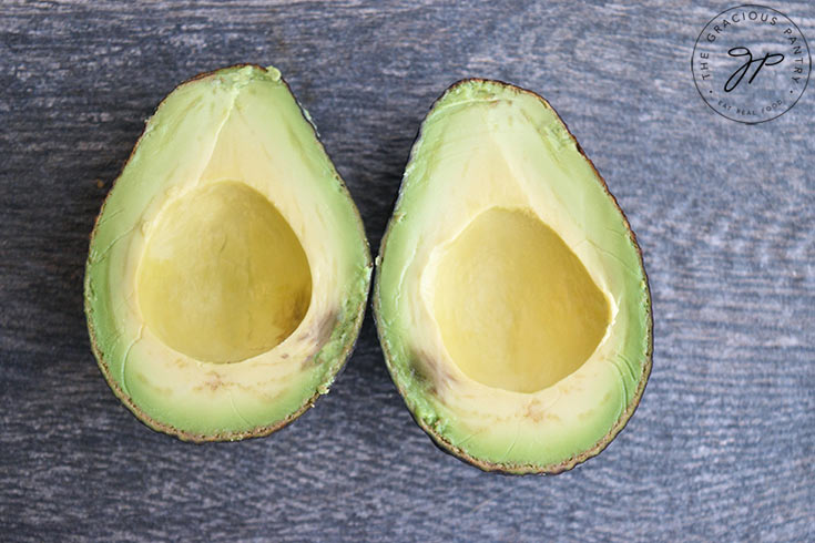 two avocado halves, side by side, with the seed removed.