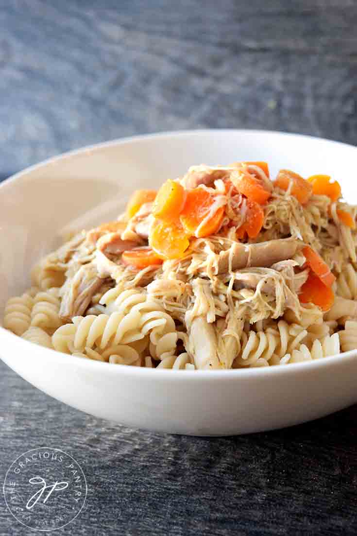 A bowl of Maple Chicken with carrot slices sitting on top.