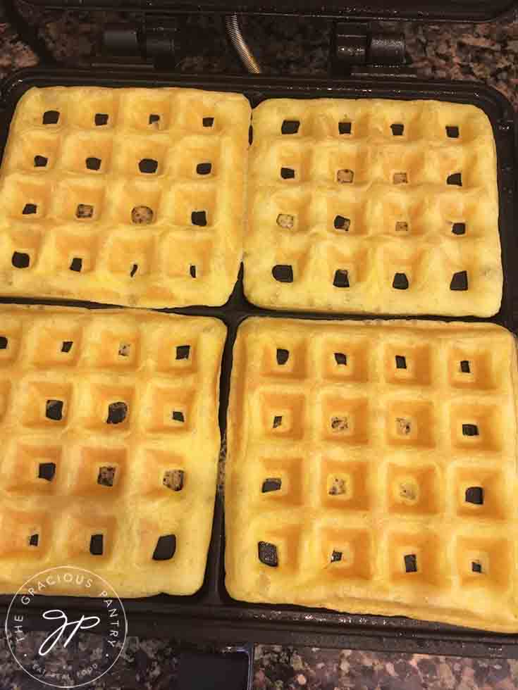Golden waffles sitting in the waffle maker, just made and ready to serve.