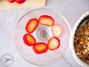 Sliced strawberries arranged in the bottom of the trifle bowl.