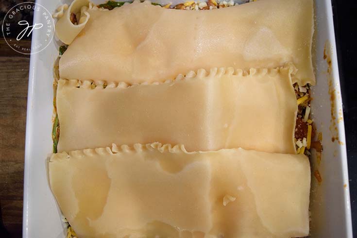 First layers of homemade lasagna in a baking pan.