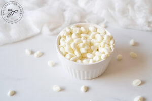 A small white bowl sits on a white surface filled with dippin dots.