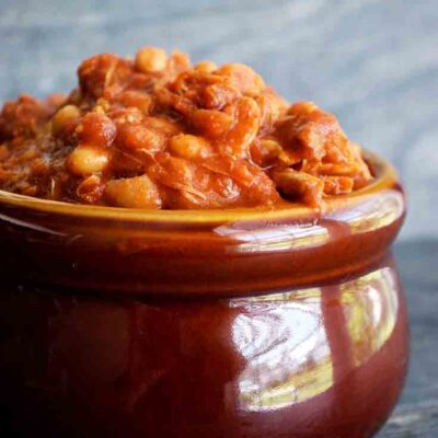 A side view of a brown crock, overfilled with this Instant Pot Chicken Chili Recipe.