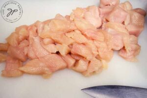 Step one of this easy orange chicken recipe is to cut the chicken into small pieces.