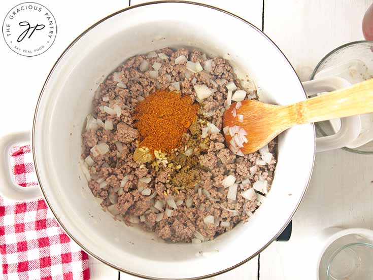 A pot of browned, ground beef with spices added.