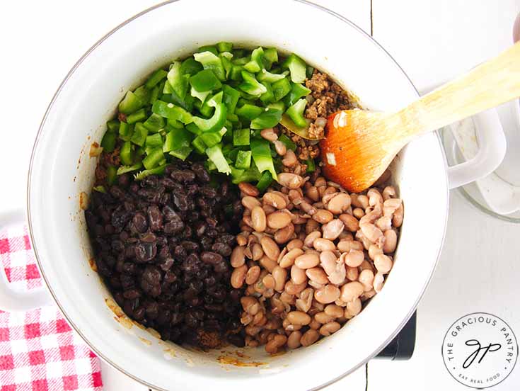 A pot with beans and green bell peppers.