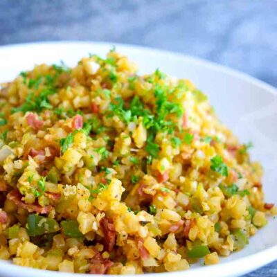 A side view of this Dirty Cauliflower Rice Recipe in a white serving bowl.