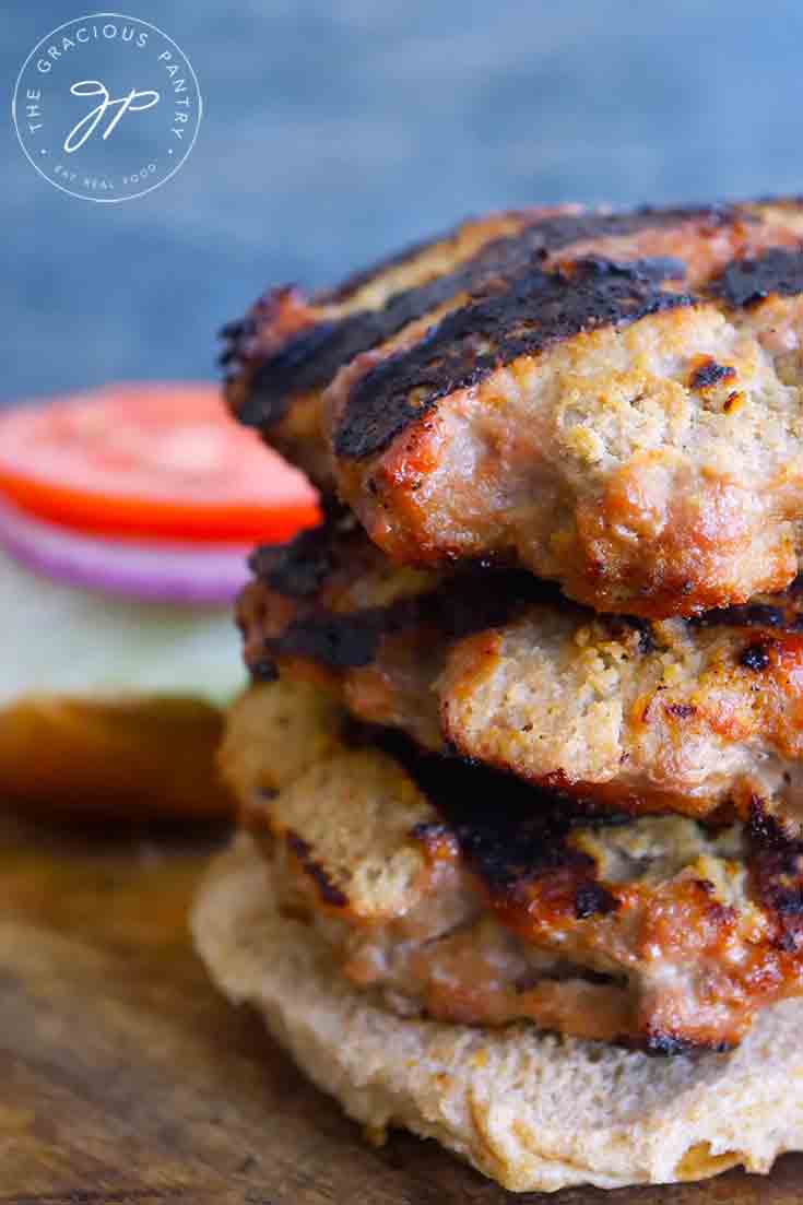 An up close shot of the three Grilled Turkey Burgers stacked high on half a burger bun.