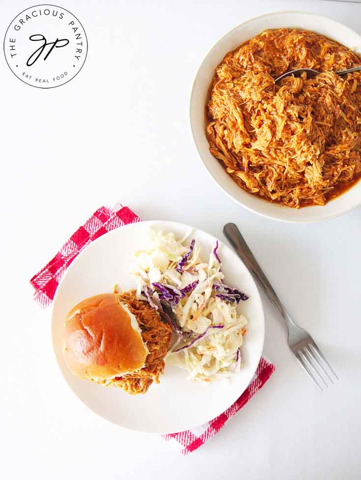 And overhead view of a chicken slider on a plate with a side of coleslaw