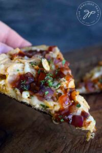 A single slice of this Naan Pizza with barbecue sauce, chicken and caramelized onions.