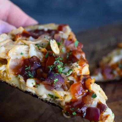 A single slice of this Naan Pizza with barbecue sauce, chicken and caramelized onions.