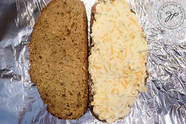 Step four is to spread the cheese over one slice of bread.