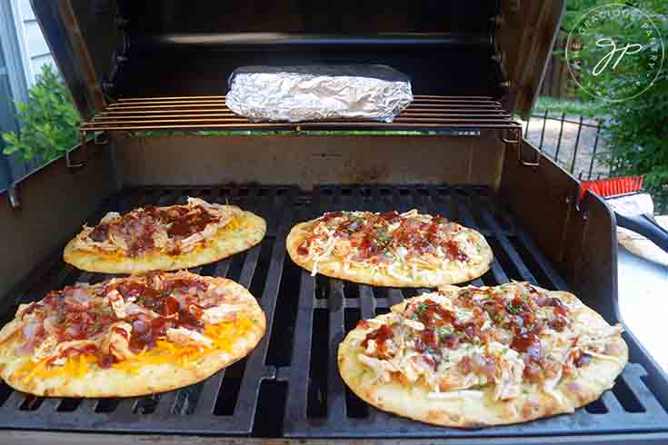 Cook the pizzas on the grill for about 10 minutes.