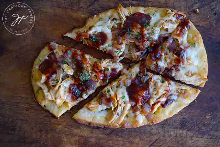 A finished, delicious Naan Pizza, cut and ready to serve.