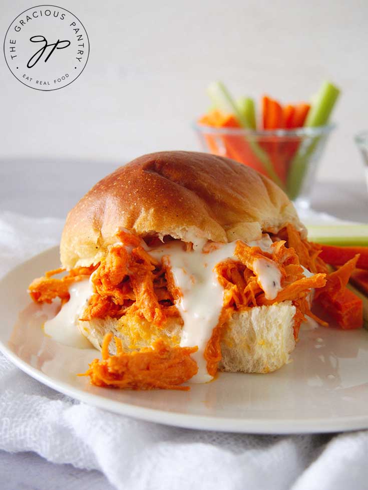 A side shot of these Buffalo Chicken Sandwiches with fresh veggies in the background.