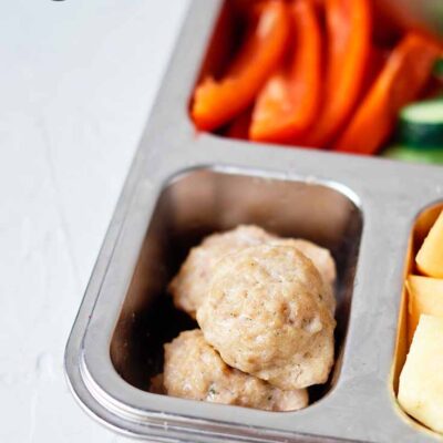 A closeup of chicken poppers in a lunchbox.