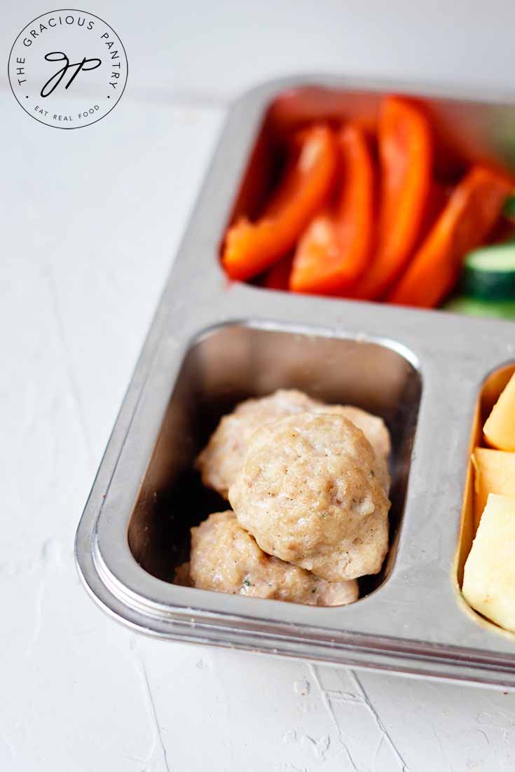 A closeup of chicken poppers in a lunchbox.