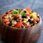 A bowl of this Cowboy Caviar Recipe in a wooden bowl.
