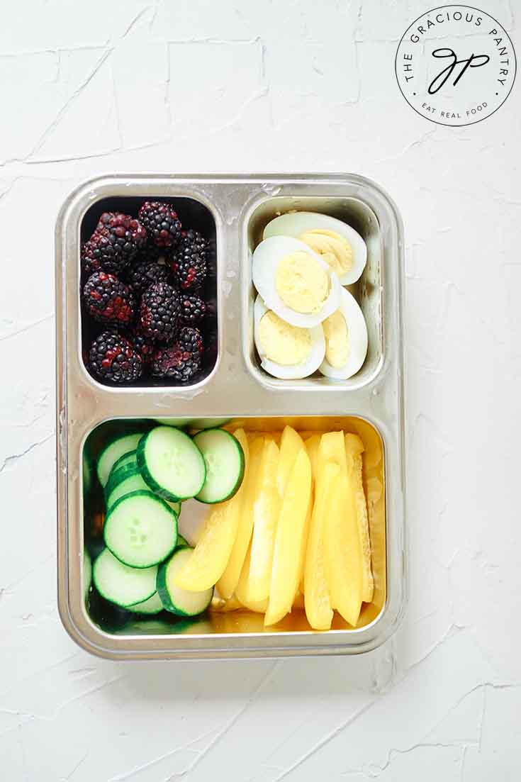 An overhead view of some healthy lunchbox snacks in a bento-style lunchbox.