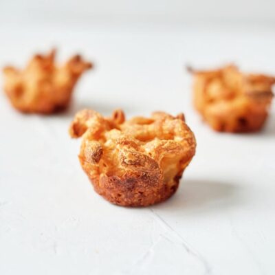 Three mac and cheese bites sit on a white background.