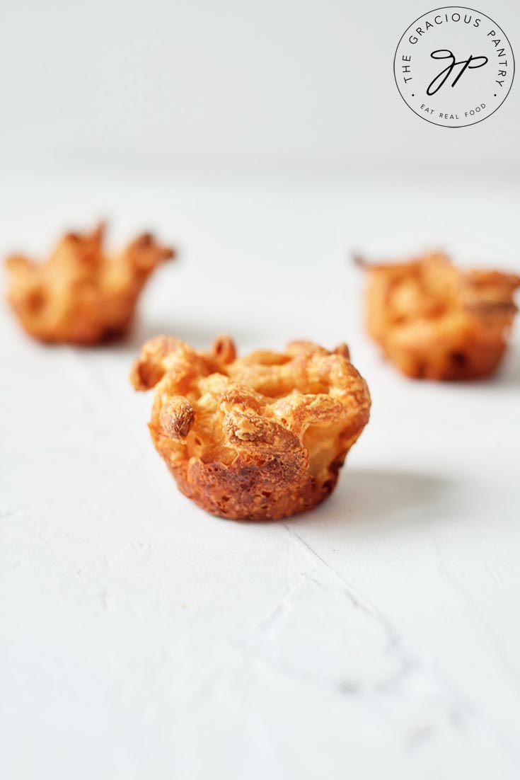 Three mac and cheese bites sit on a white background.