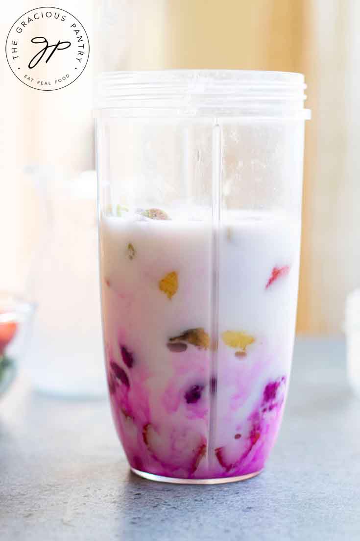 Pink dragon fruit smoothie ingredients in a blender cup.