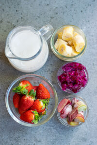 pink dragon fruit smoothie ingredients in individual bowls.