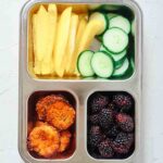 Overhead view of quinoa muffins in a bento-style lunchbox.