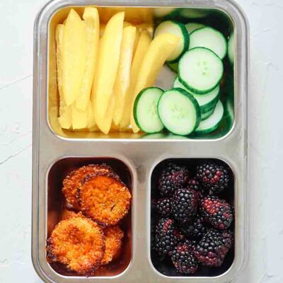 Overhead view of quinoa muffins in a bento-style lunchbox.