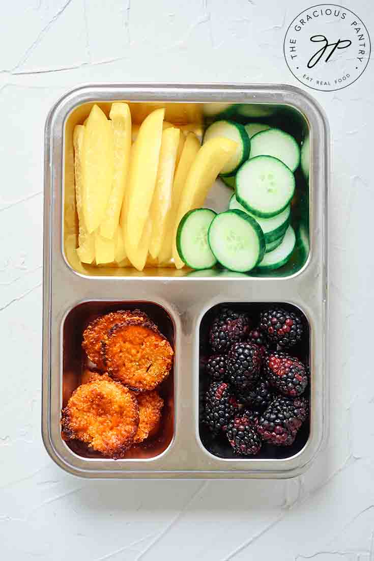 Overhead view of quinoa muffins in a bento-style lunchbox.