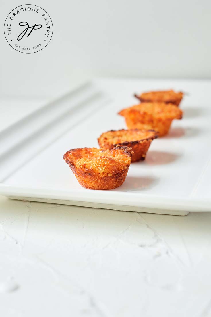 Quinoa muffins lined up on a serving platter in a single-file line.