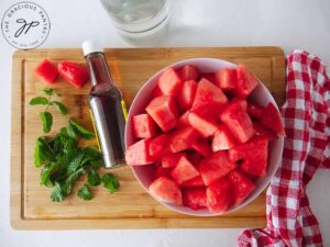Cut chunks of watermelon in a bowl.