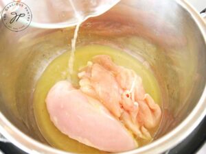Add the chicken and broth to the Instant Pot.