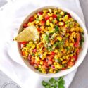 An overhead view of a white bowl filled with this Corn Salsa Recipe.