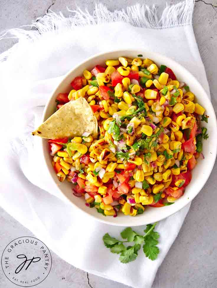 An overhead view of a white bowl filled with this Corn Salsa Recipe.