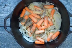 Spices over the carrots and onions in the dutch oven.