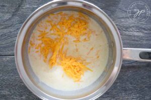 Grated cheddar cheese added to milk mixture.