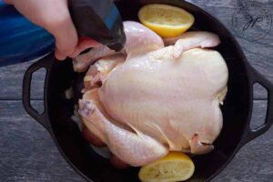 Spritzing oil over the chicken with an oil sprayer.