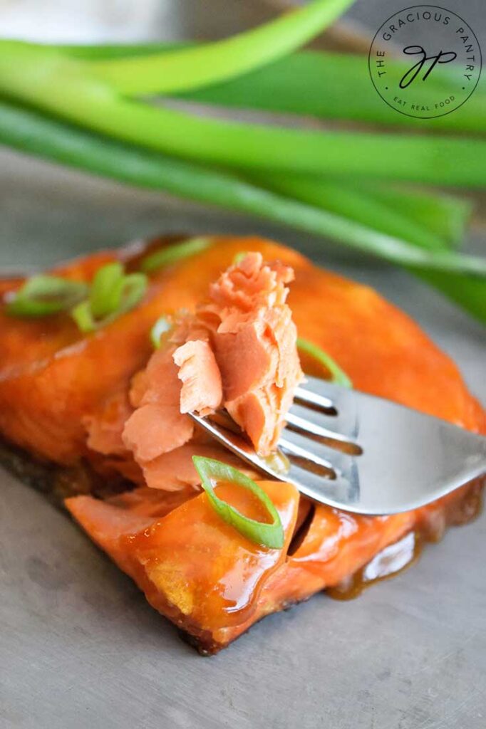 A Teriyaki Salmon Fillet with a fork holding a single bite.